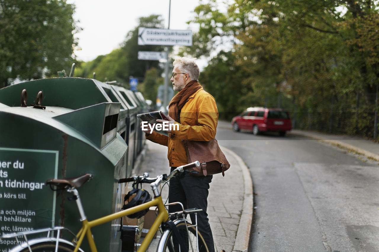 Man putting garbage into recycling bin