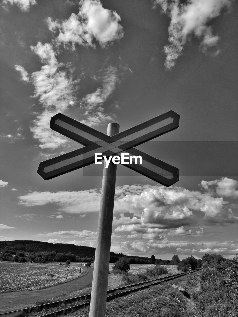 Low angle view of crossing sign against sky