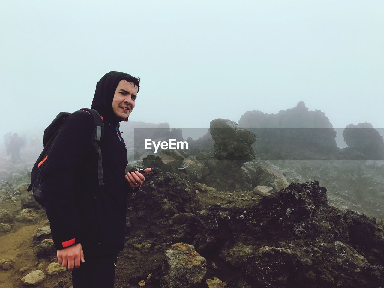 Portrait of smiling woman standing on mountain