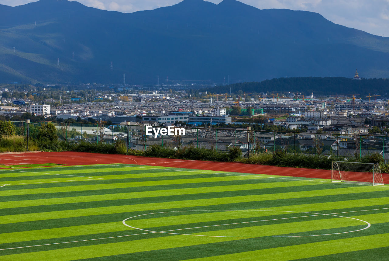 HIGH ANGLE VIEW OF SOCCER FIELD AGAINST SKY