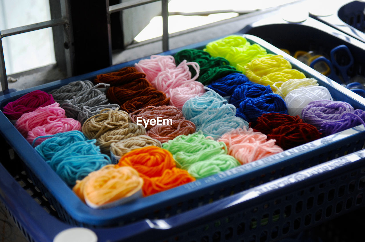 High angle view of multi colored wool in crate for sale