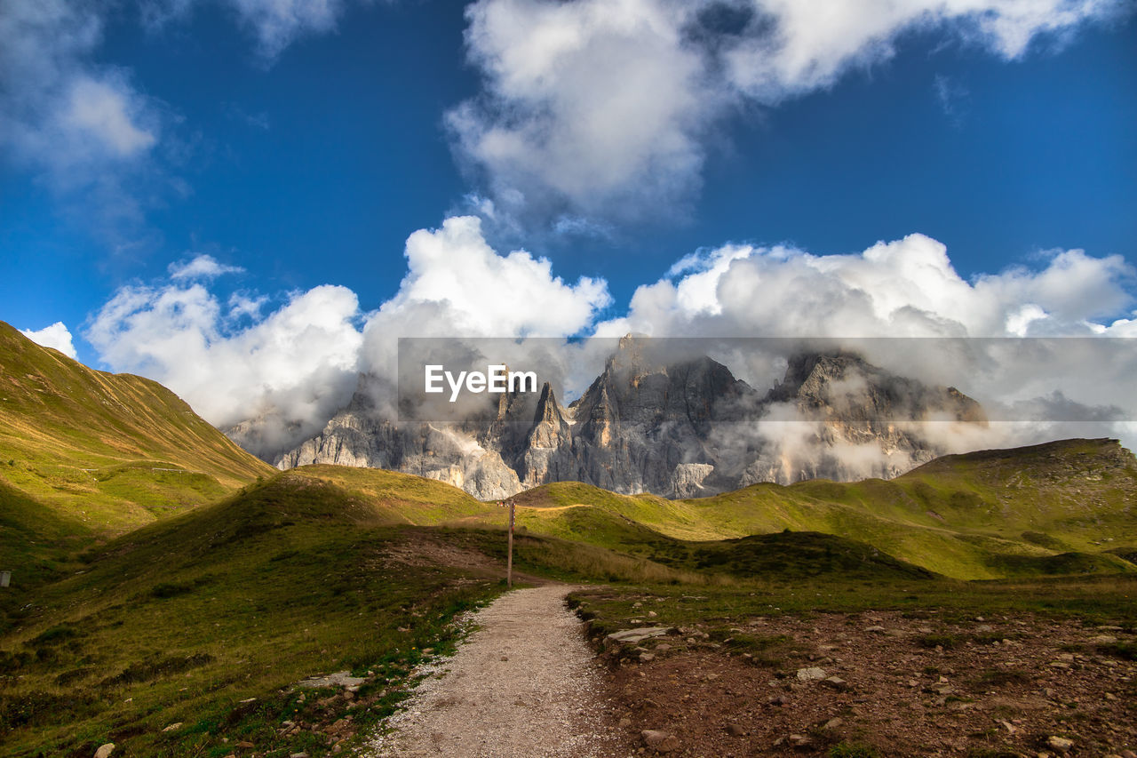 Road by mountains against sky