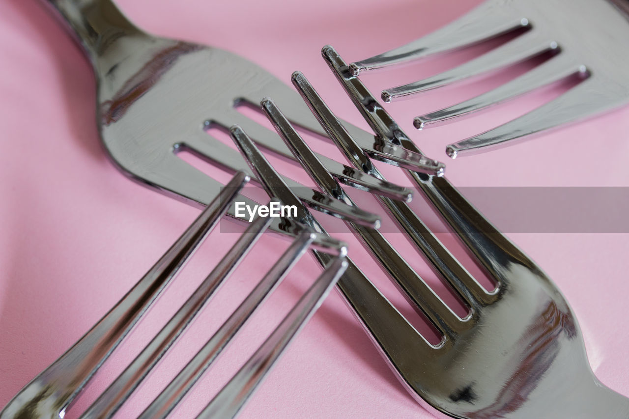 High angle view of forks on pink background