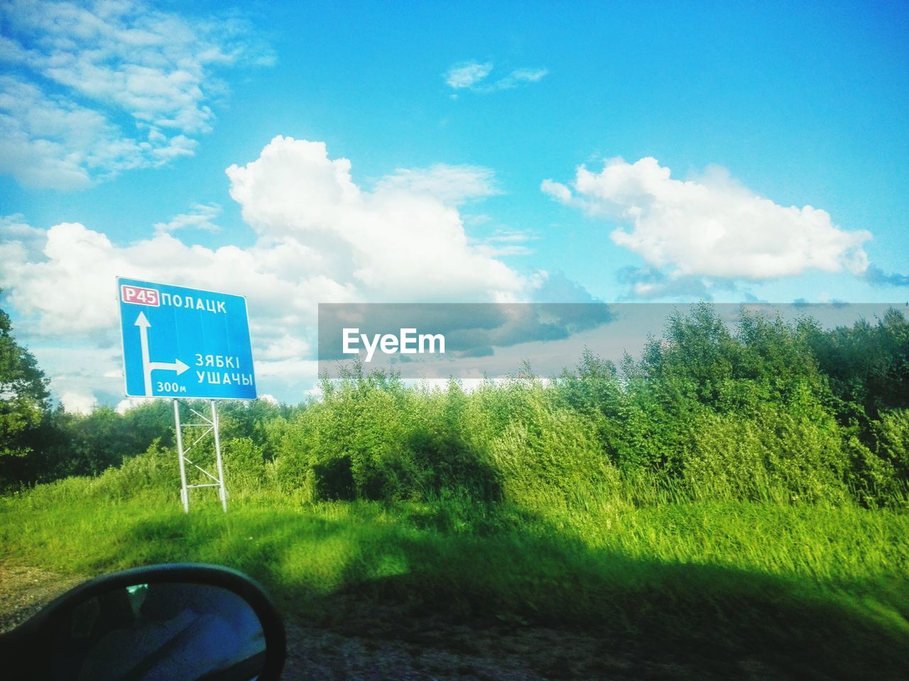 SIGNBOARD ON ROAD AGAINST CLOUDY SKY