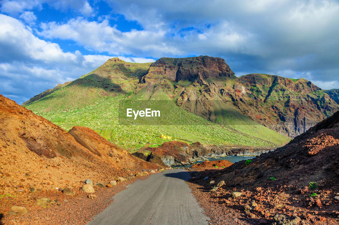 Scenic view of road amidst mountains against sky