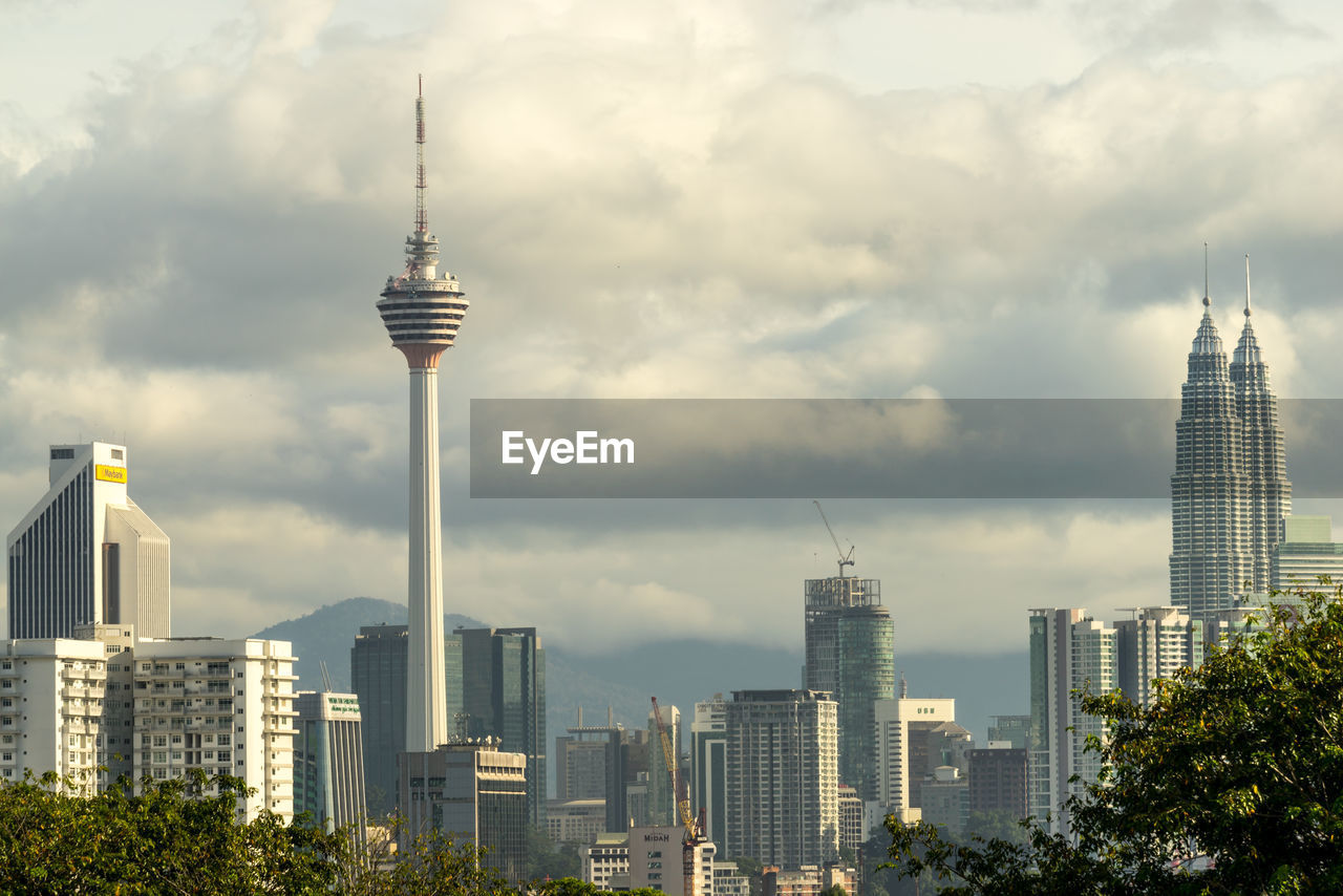 Skyscrapers in city against cloudy sky