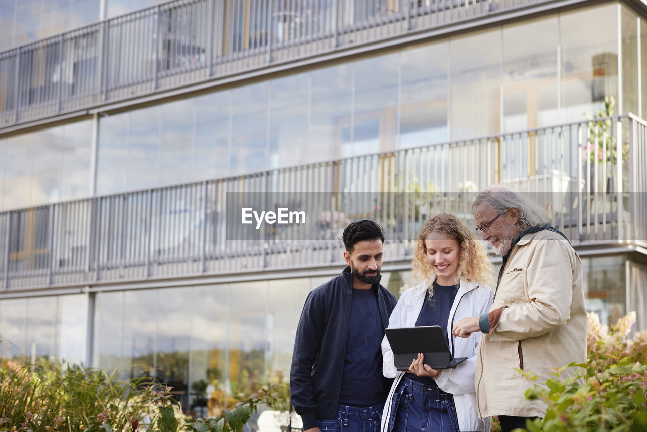 Men and woman with laptop looking in courtyard