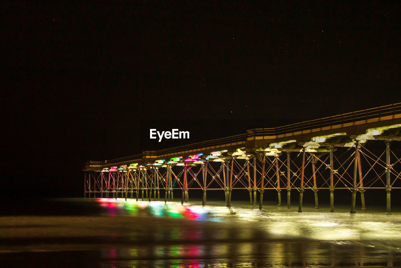Illuminated bridge over river in city at night saltburn pier