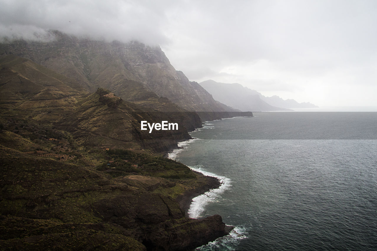 SCENIC VIEW OF SEA AND MOUNTAIN AGAINST SKY