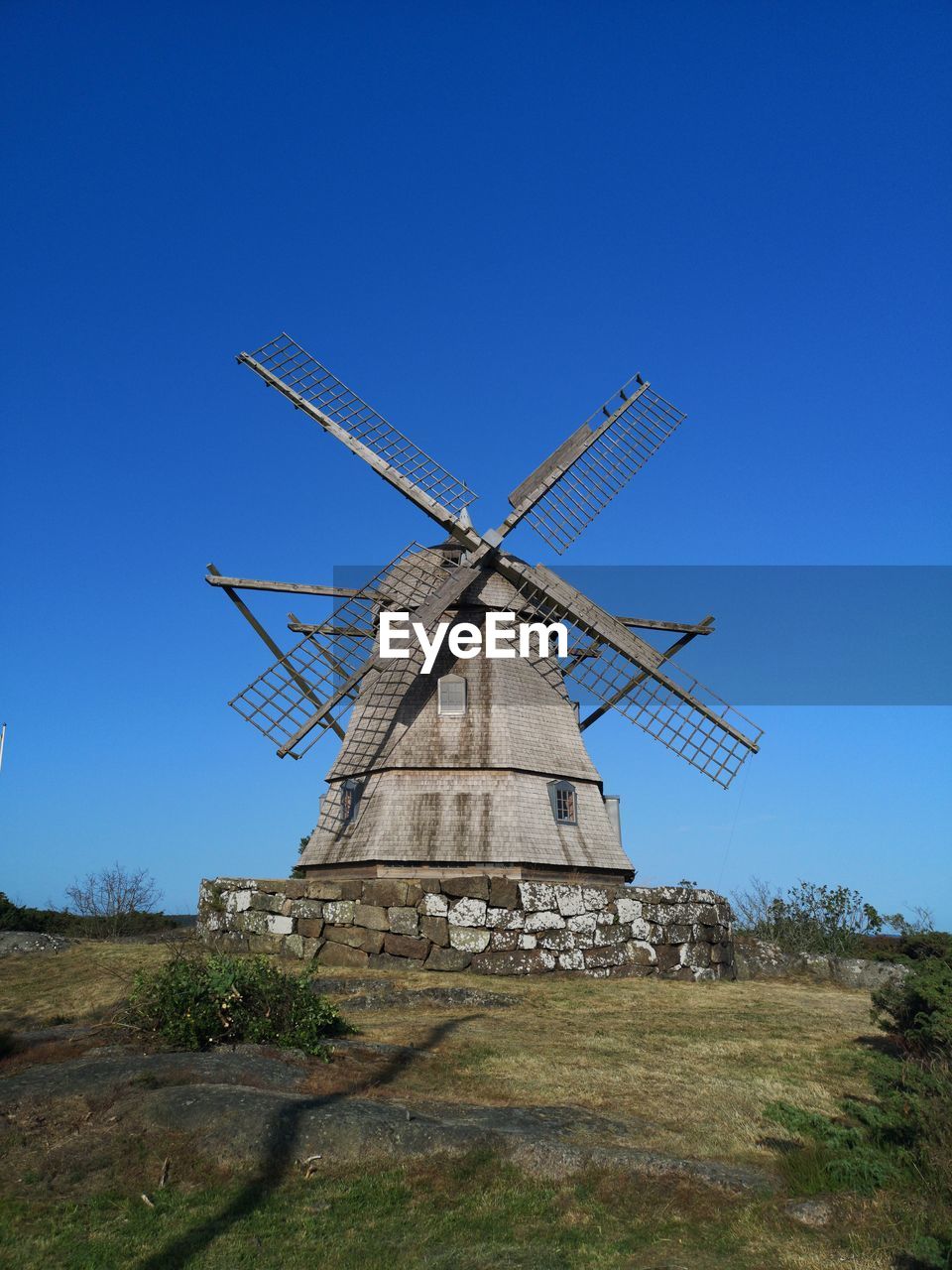 LOW ANGLE VIEW OF TRADITIONAL WINDMILL ON FIELD AGAINST SKY