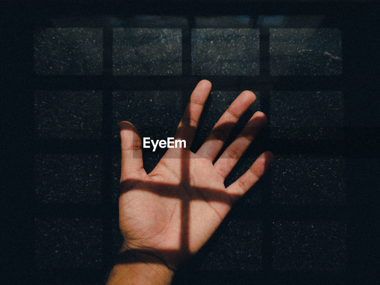 CLOSE-UP OF HUMAN HAND TOUCHING WALL