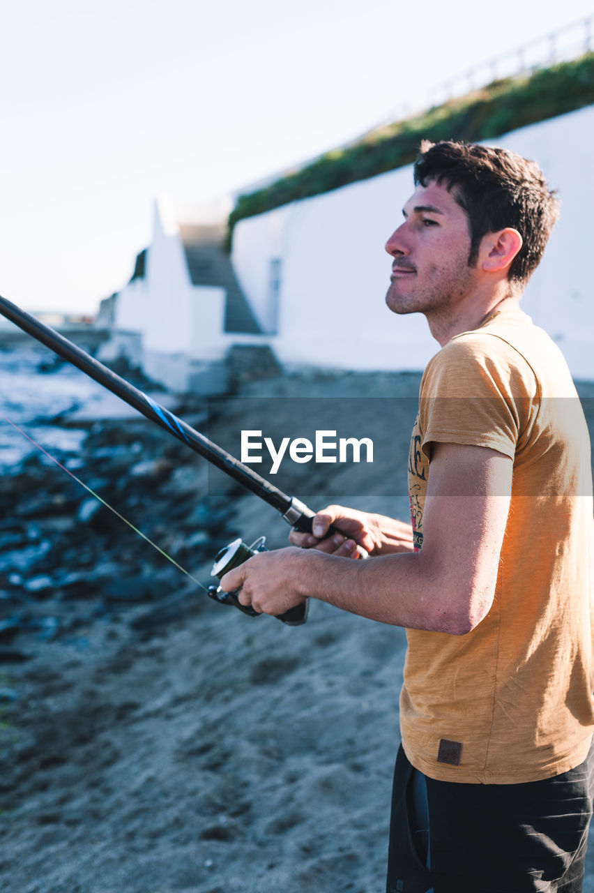 SIDE VIEW OF MAN HOLDING SEA