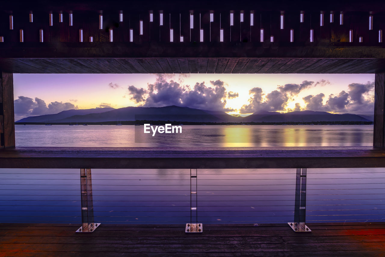 Sea seen through empty billboard during sunset