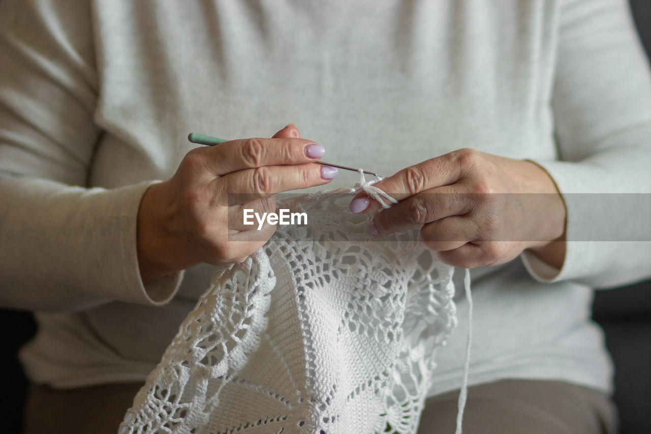 midsection of bride holding wedding dress