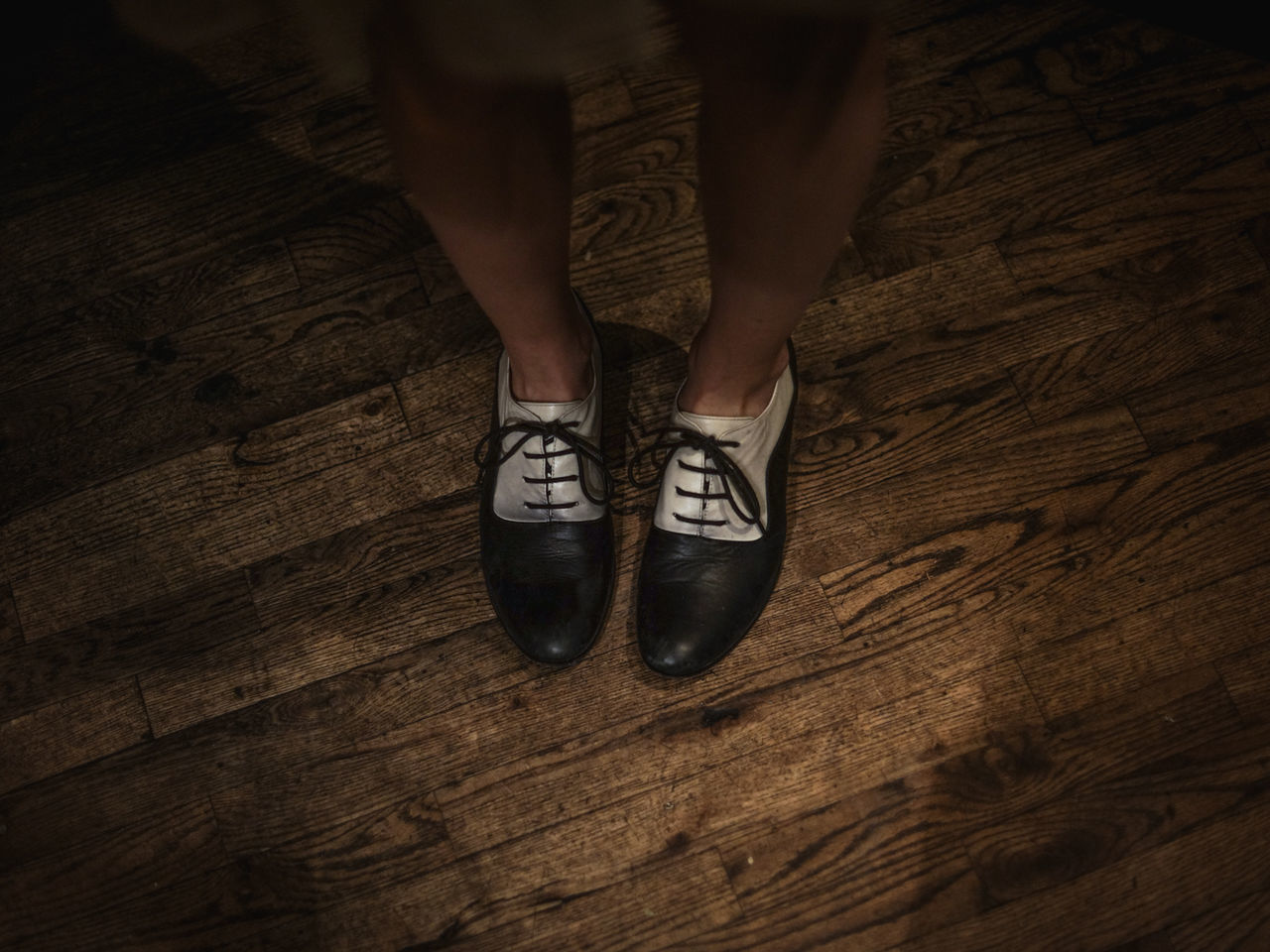 High angle view of woman wearing shoes on hardwood floor