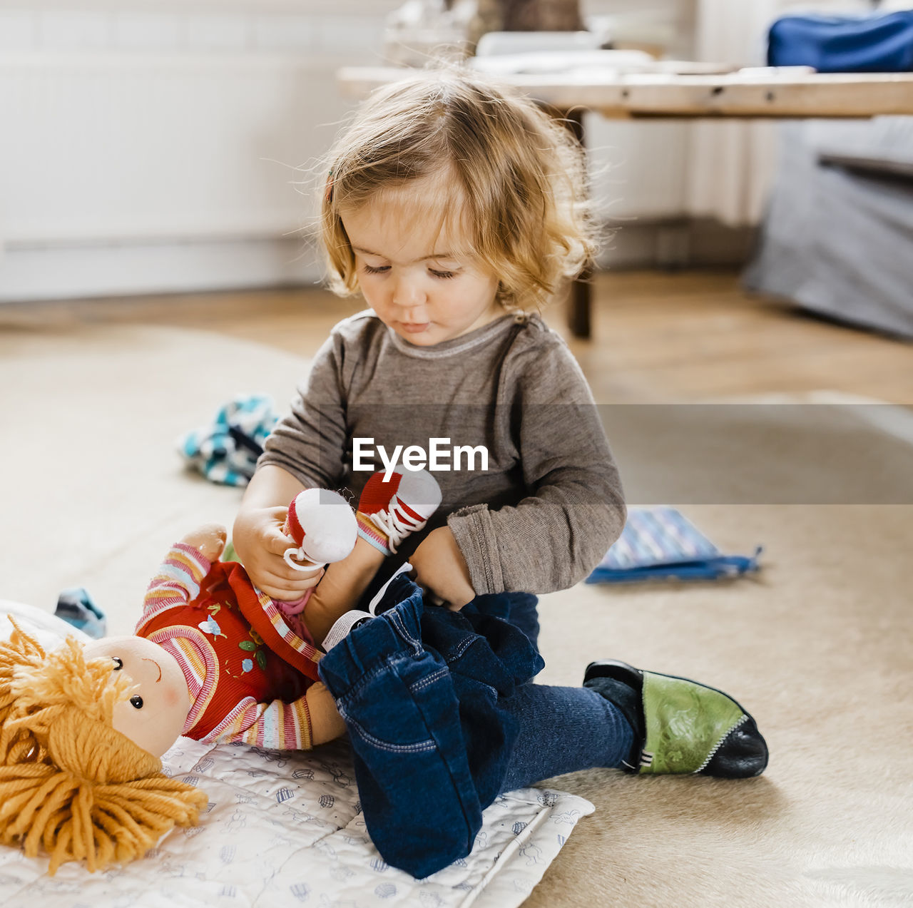 Cute boy sitting on wooden floor at home