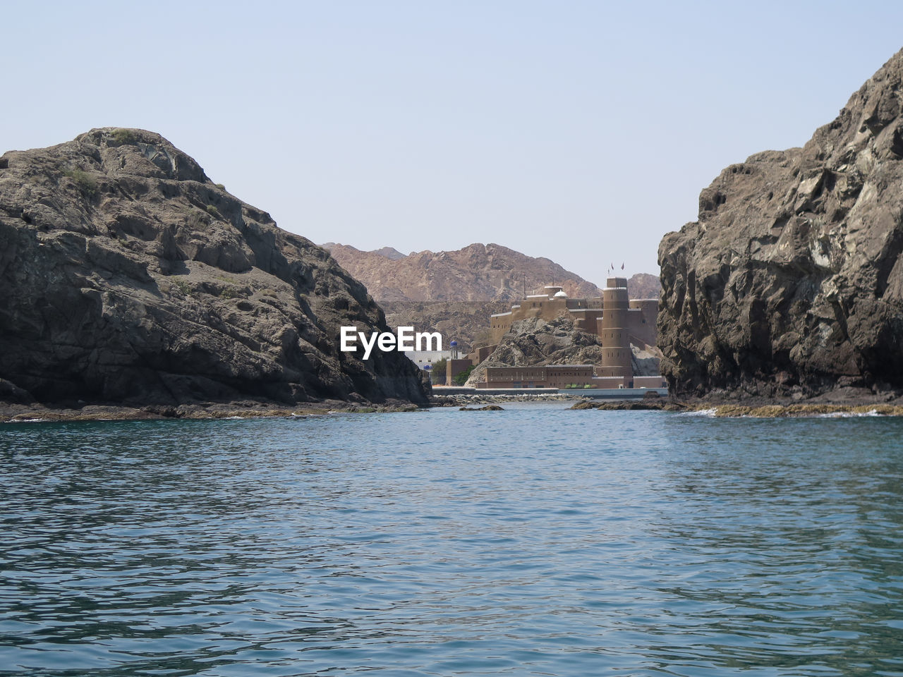 Scenic view of sea and mountains against clear sky