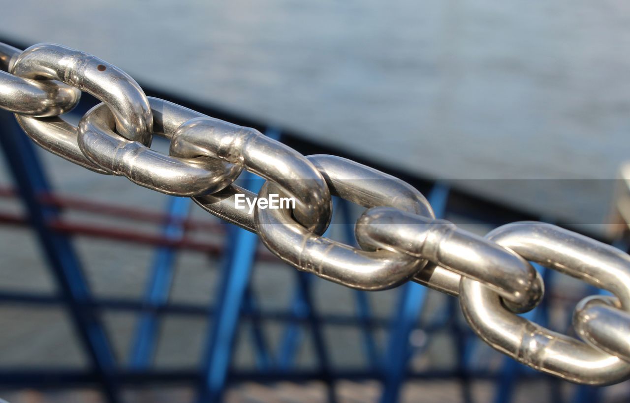 CLOSE-UP OF CHAIN AGAINST WATER