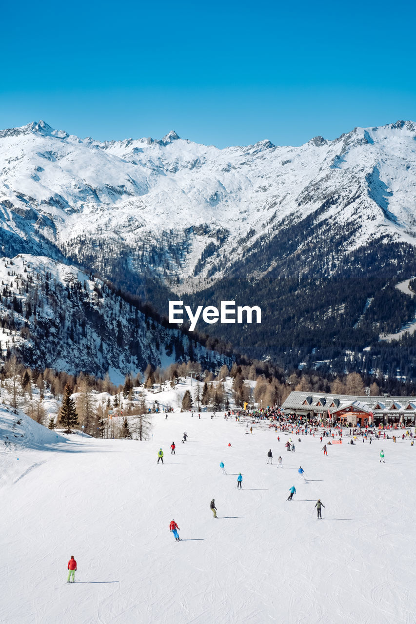 People skiing against snowcapped mountains