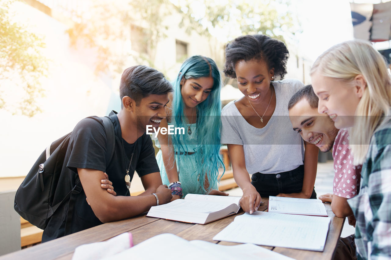 Cheerful friends studying at campus