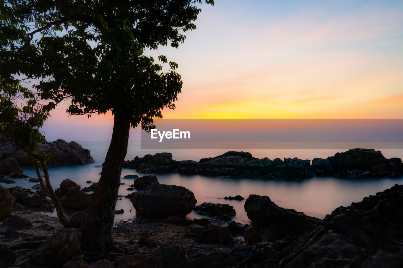 SCENIC VIEW OF ROCKS AT BEACH AGAINST SKY