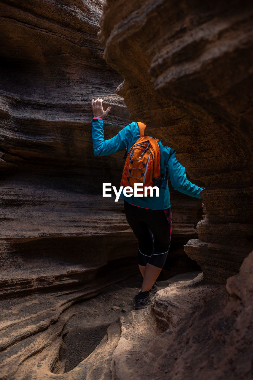 Rear view of woman standing on rock formation