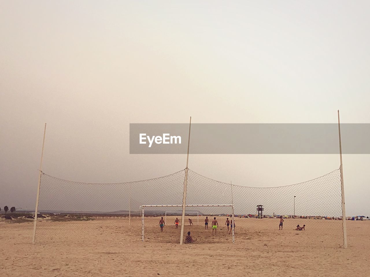 Men playing beach soccer