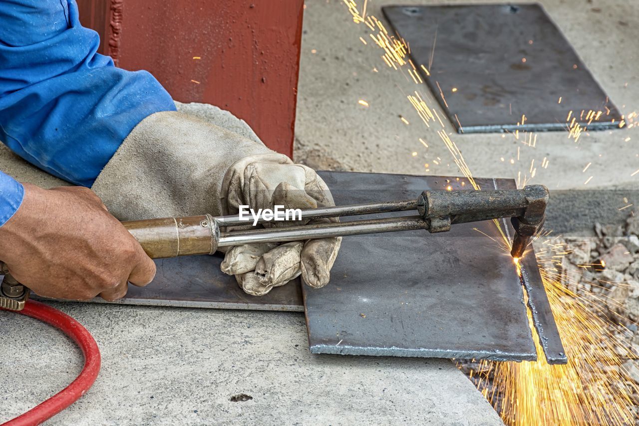 Cropped hands of worker welding metal