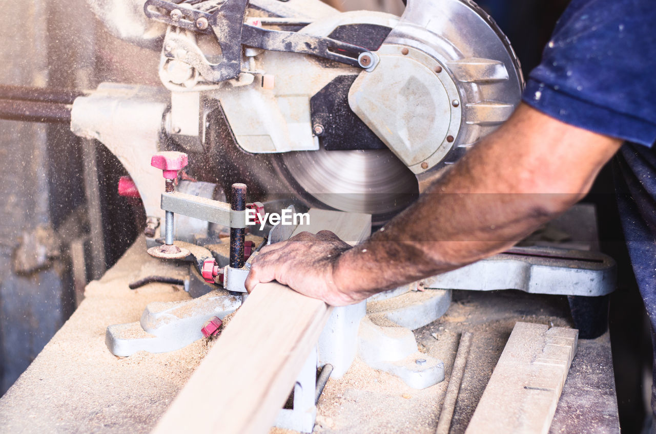 Midsection of carpenter working on wood