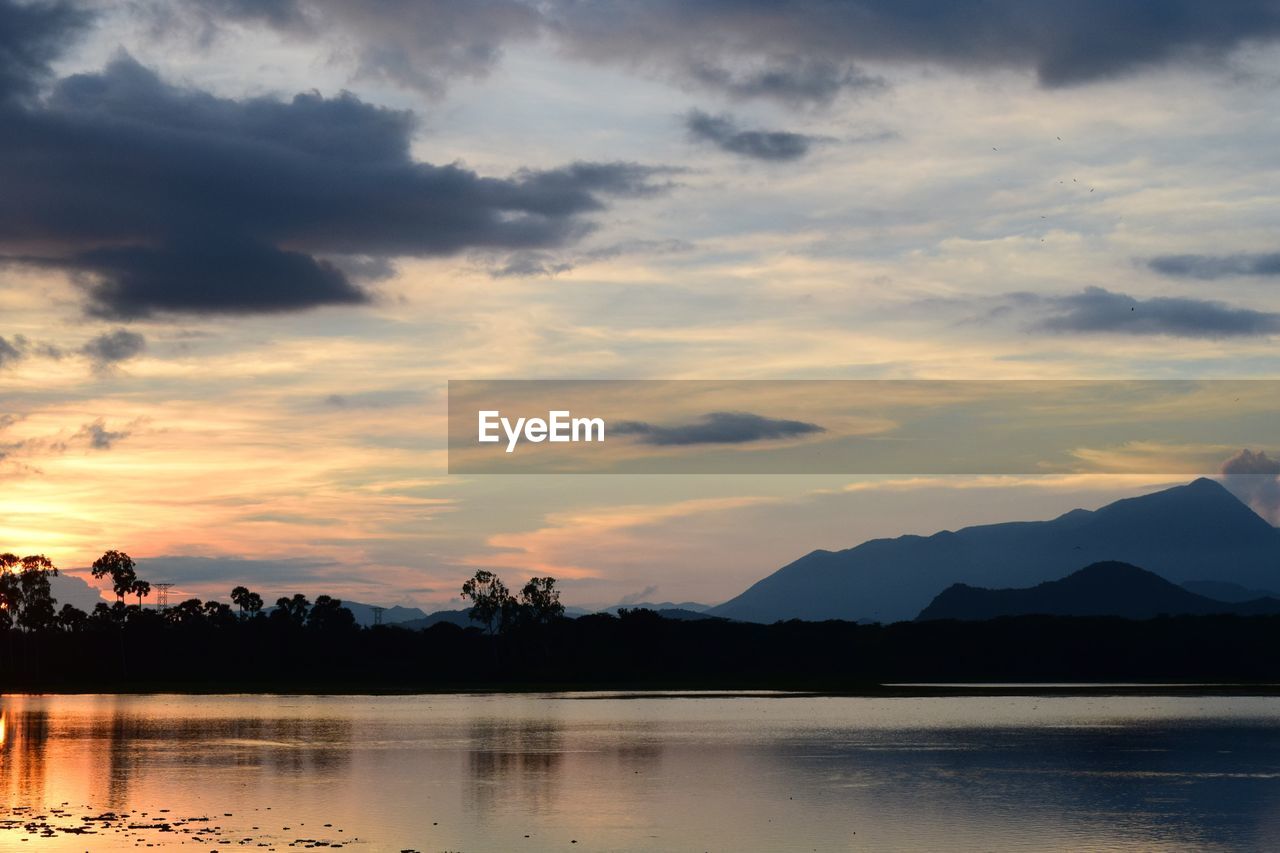 SCENIC VIEW OF LAKE AGAINST SKY AT SUNSET