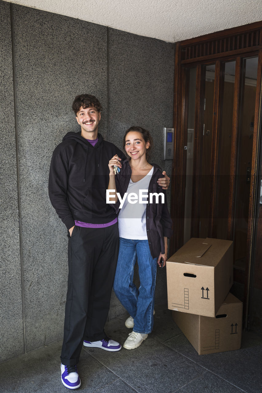 Portrait of smiling couple with boxes and keys