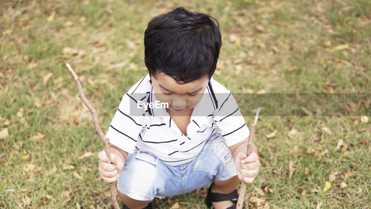 High angle view of boy playing with sticks at park