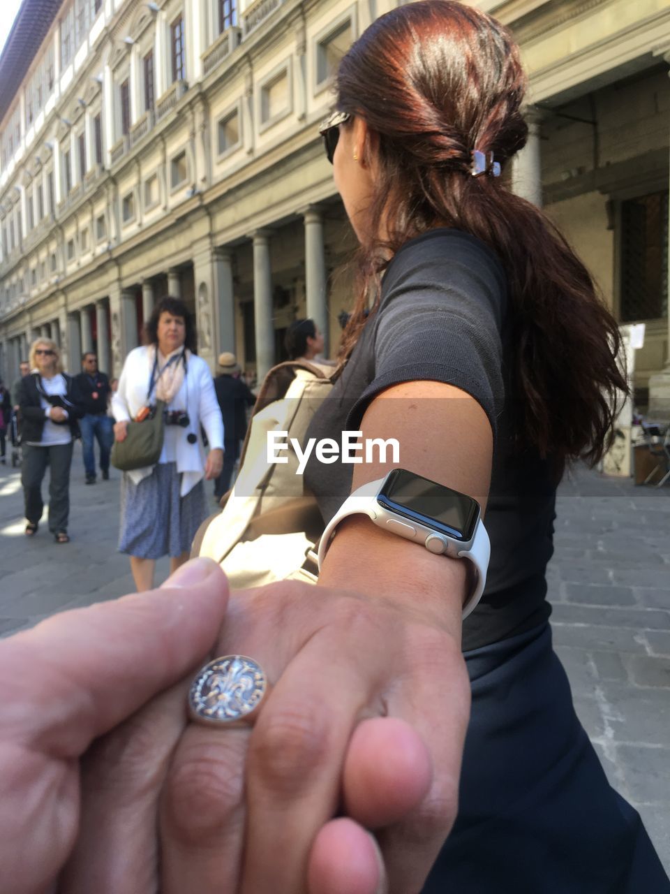 MIDSECTION OF WOMAN WITH UMBRELLA IN BUILDING