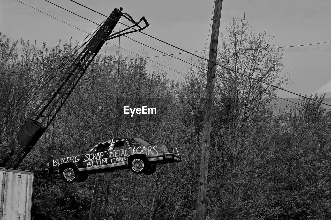 Crane lifting abandoned car at junkyard