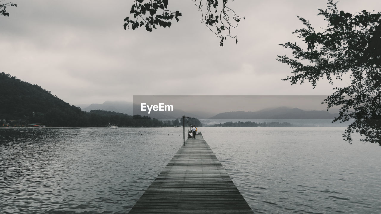 Pier over lake against sky