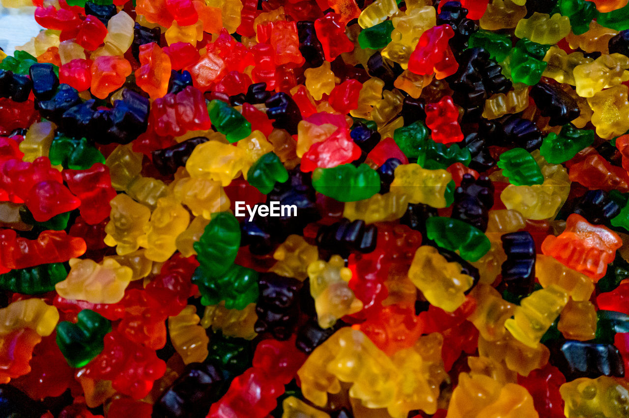 HIGH ANGLE VIEW OF MULTI COLORED CANDIES IN CONTAINER