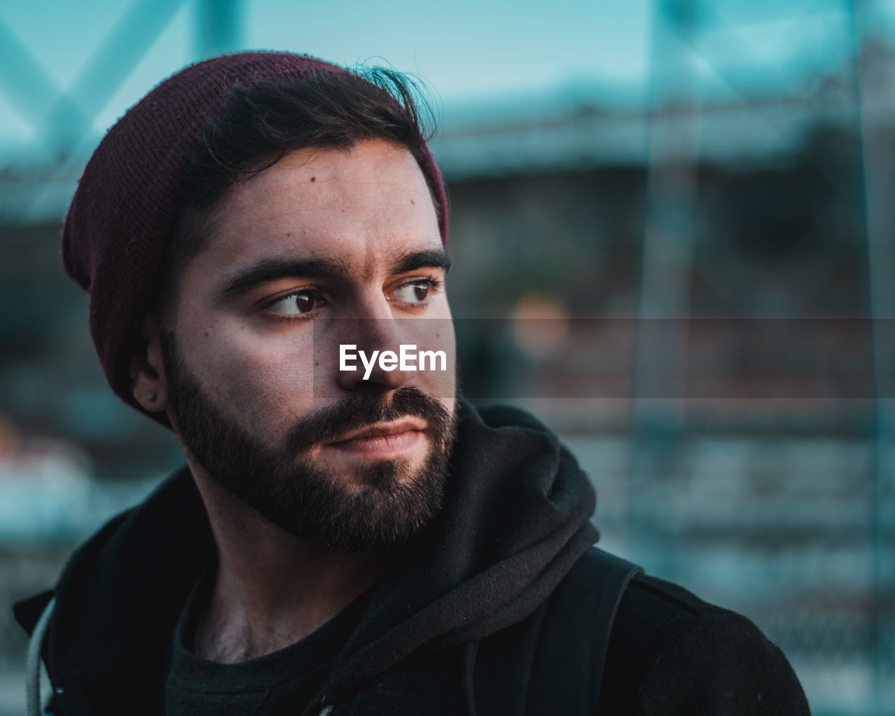 Close-up of thoughtful young man looking away in city