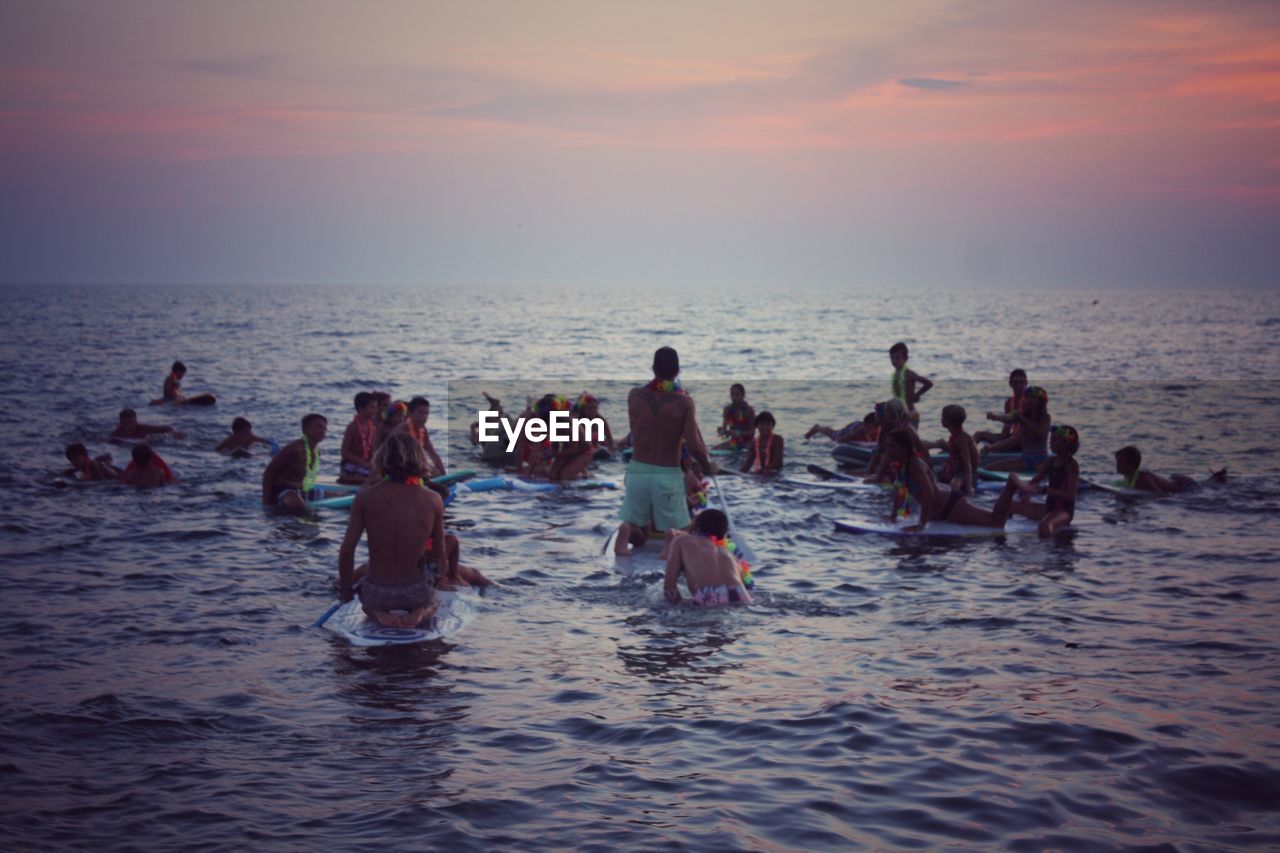 People enjoying in sea against clear sky