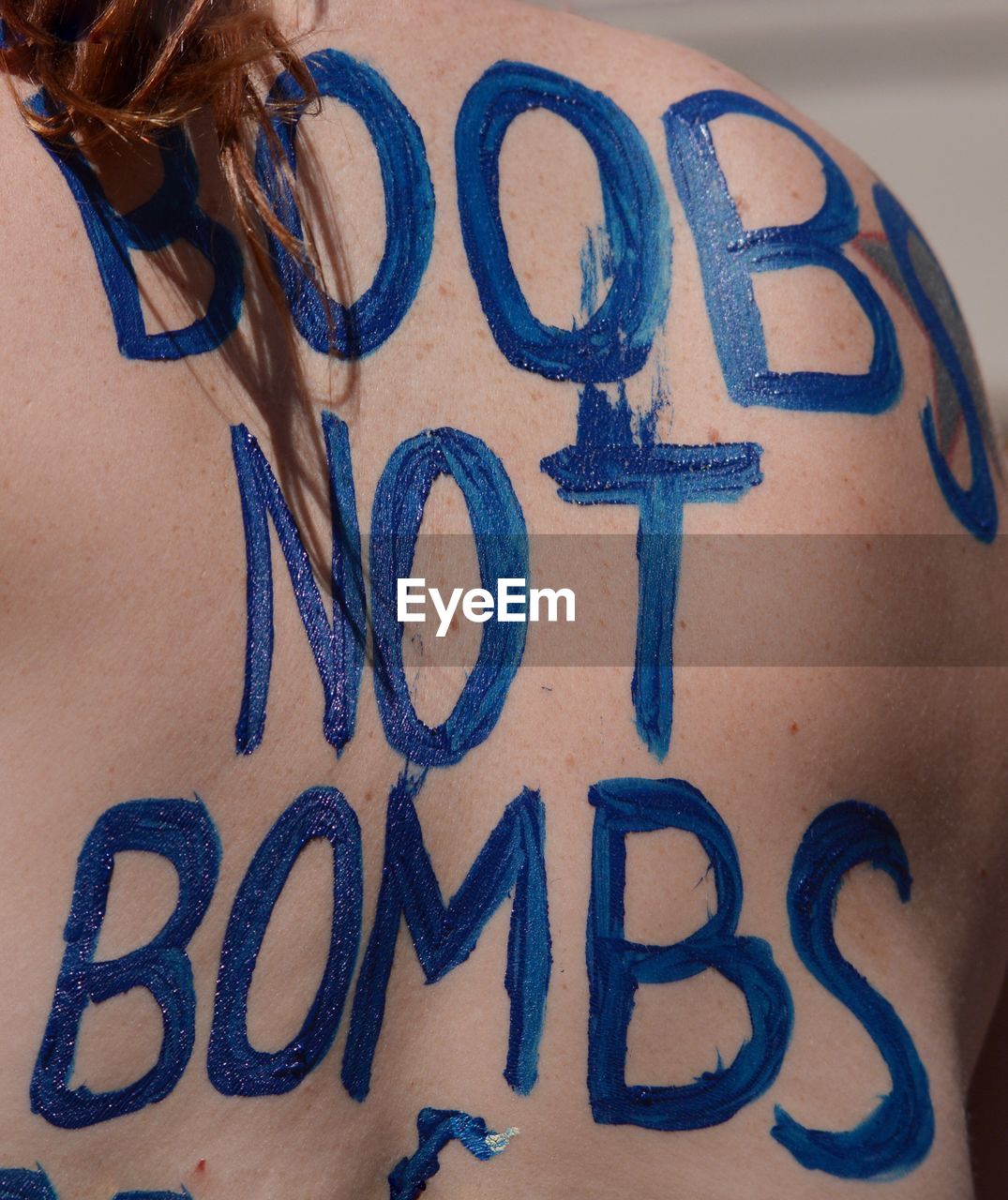 Rear view of shirtless woman with message on back