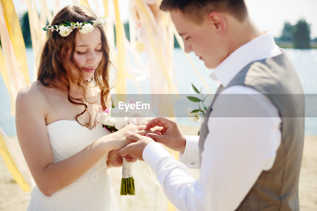 COUPLE HOLDING BOUQUET OF PEOPLE AT HOME