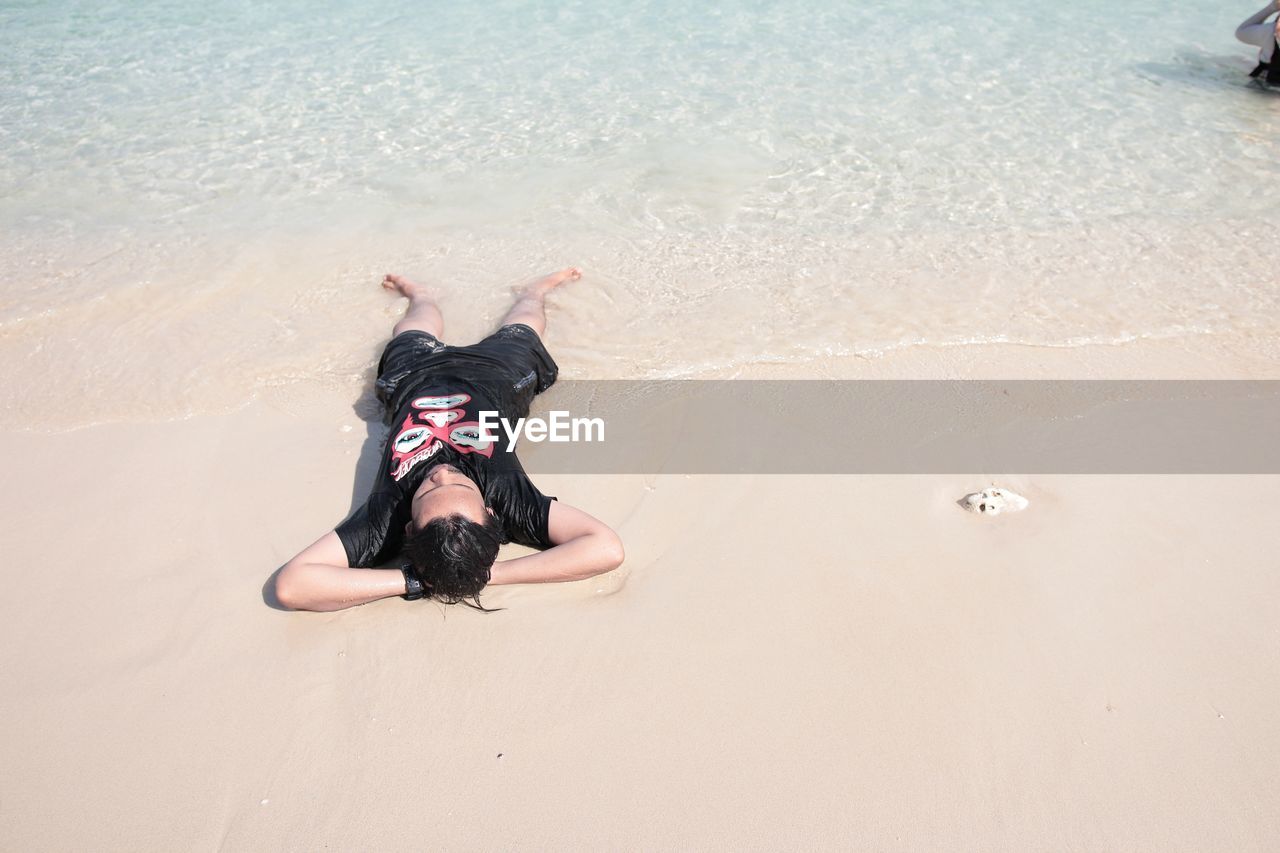 High angle view of man lying down at beach