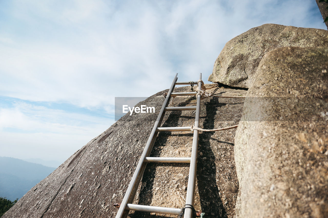 LOW ANGLE VIEW OF WOODEN POSTS AGAINST SKY