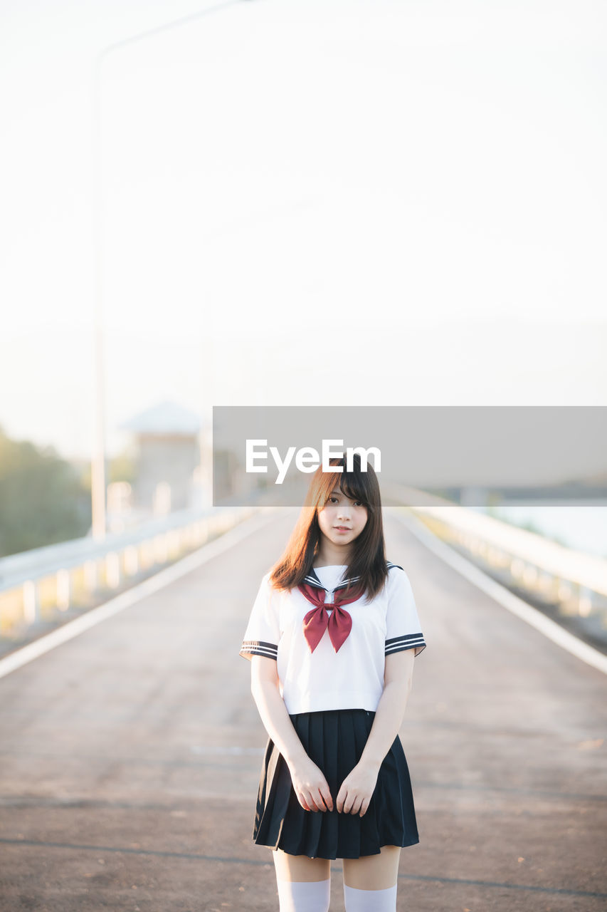 Portrait of smiling woman standing on road