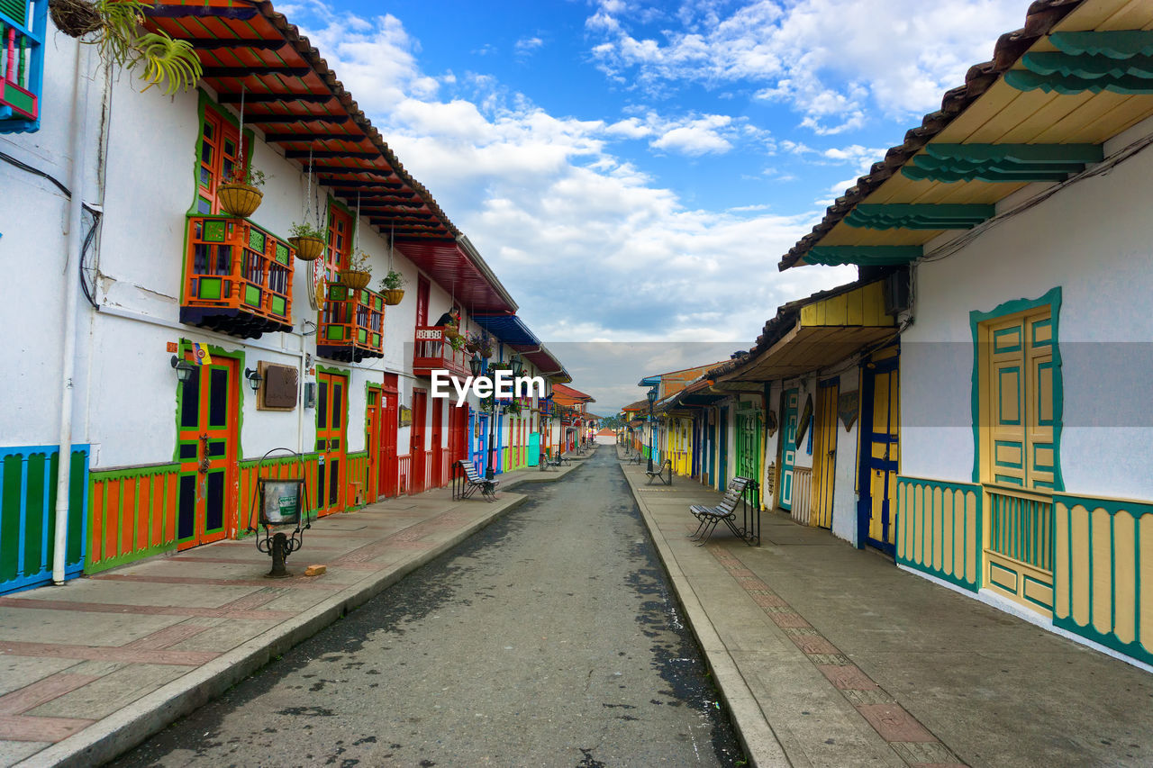 Colorful houses in street of salento against cloudy sky