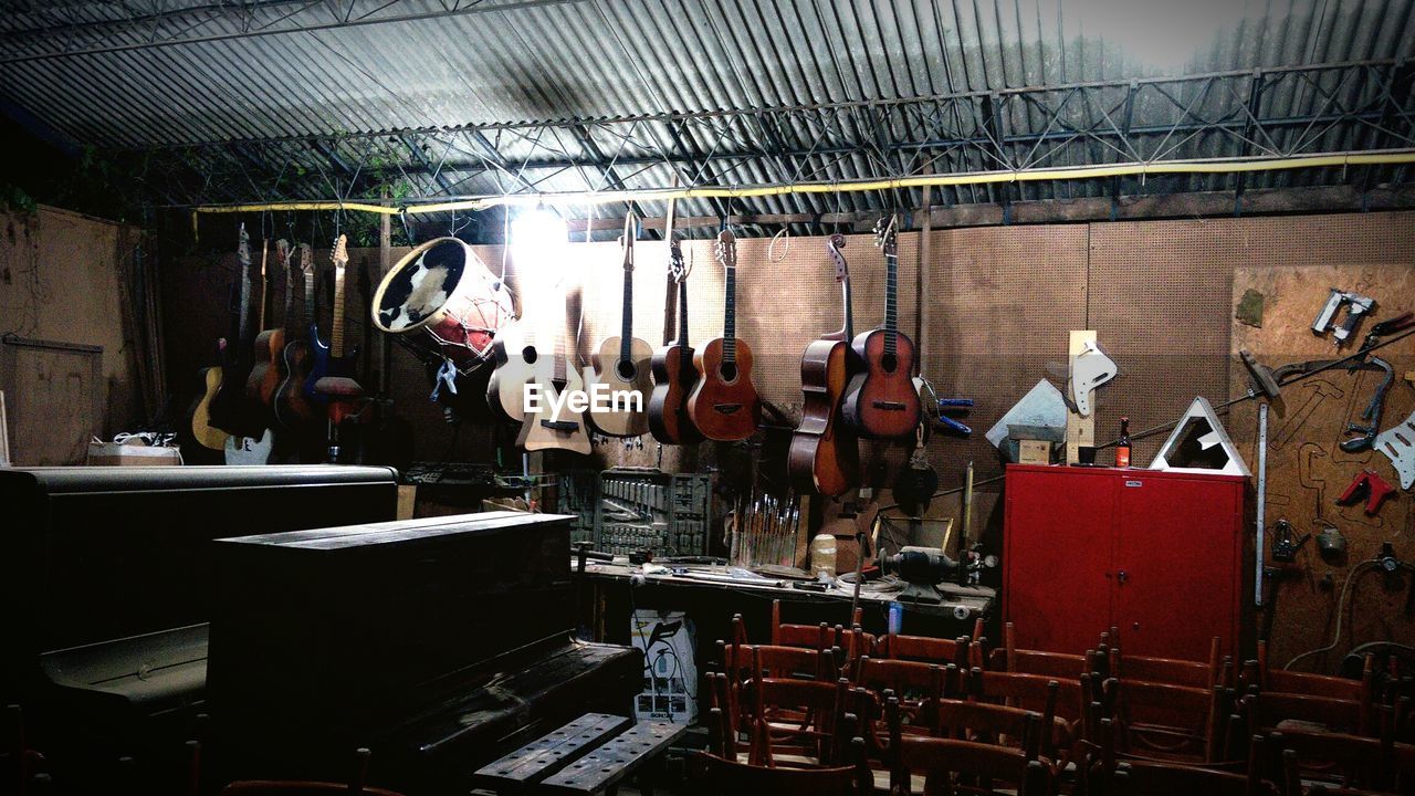 Musical instruments hanging in illuminated workshop