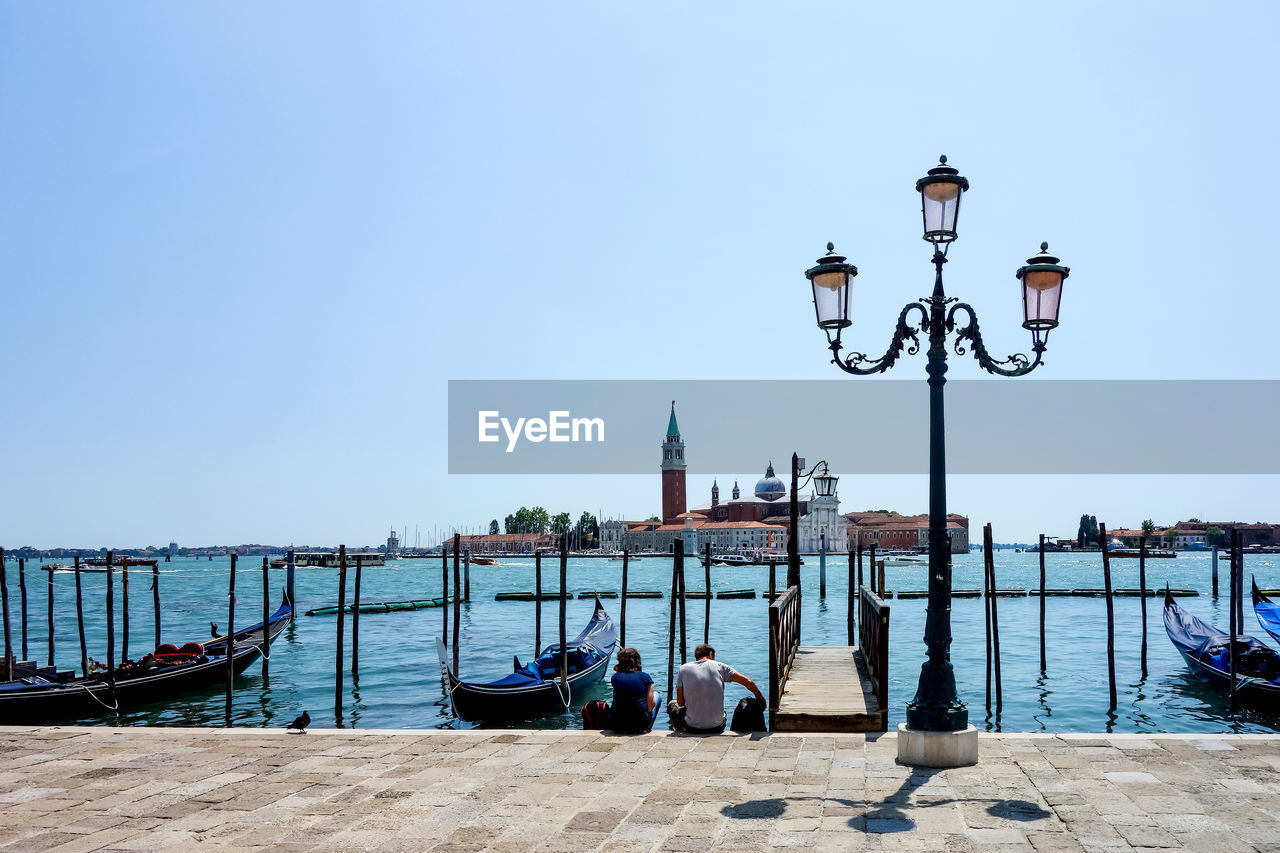 Street light on jetty against clear sky