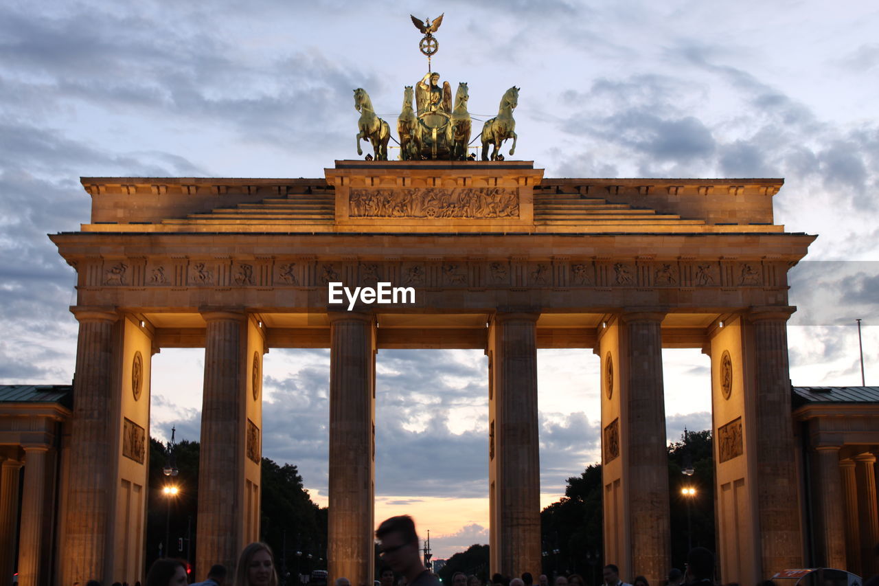 Low angle view of brandenburg gate against cloudy sky