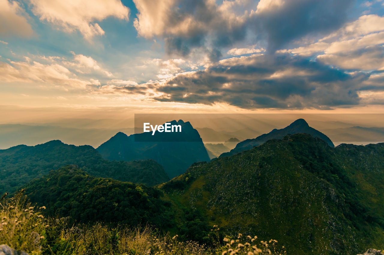Beautiful scenic mountain background with blue sky, cloud and blast horizon sun