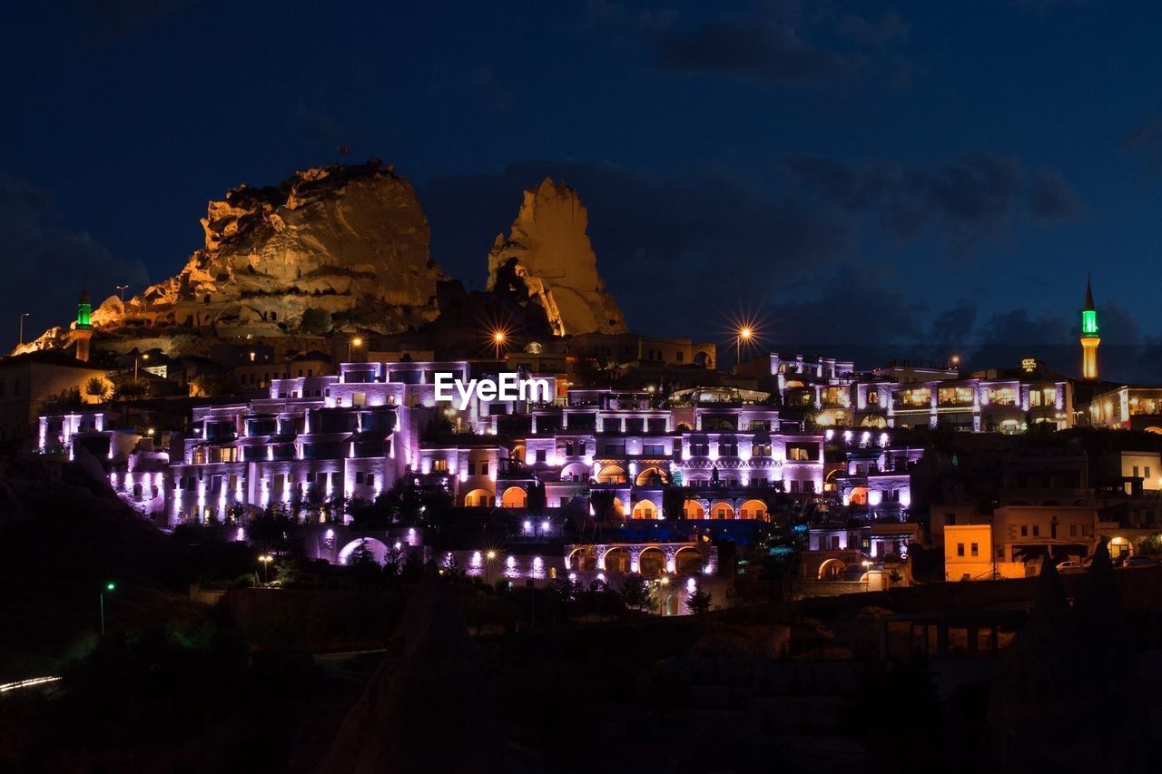 Illuminated cityscape against sky at night