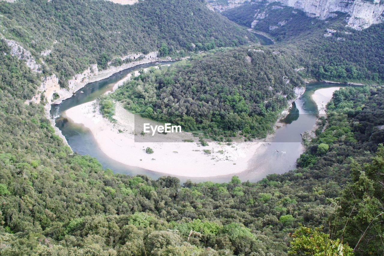 HIGH ANGLE VIEW OF RIVER AMIDST MOUNTAINS